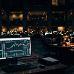 Dark prediction market trading interface glowing on a monitor against a deep navy background, representing insider trading risk in prediction markets